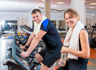 man and woman on exercise bikes